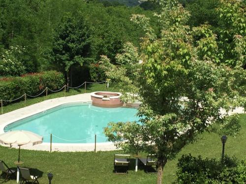 una piscina en un patio con un árbol en Belvilla by OYO Rosa Cremisi, en Apecchio