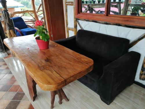 a wooden table and a couch with a potted plant on it at Cabañas Guacari San Agustín huila in San Agustín