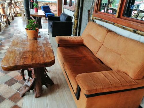 a wooden couch and a table in a room at Cabañas Guacari San Agustín huila in San Agustín
