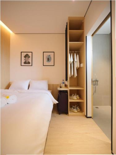 a bedroom with a white bed and a walk in closet at Cool Living in Jakarta