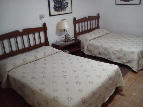 a bedroom with two beds and a table with a lamp at CasaGrande Posada Ejecutiva in Cuernavaca