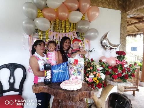 two women and two children standing next to a table with a cake at Cabañas Guacari San Agustín huila in San Agustín