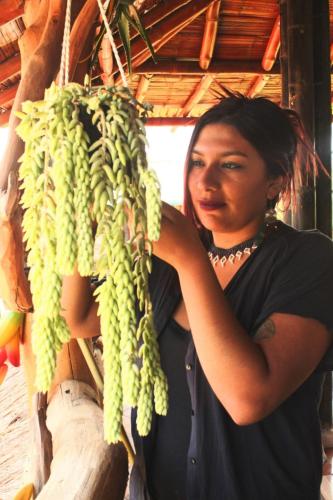 a woman is standing next to a bunch of bananas at Cabañas Guacari San Agustín huila in San Agustín