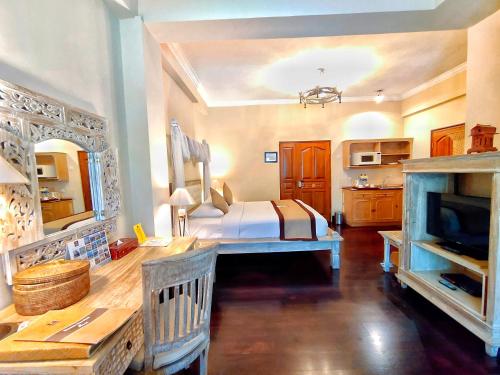 a bedroom with a bed and a tv in a room at Jayakarta Hotel Lombok in Senggigi 