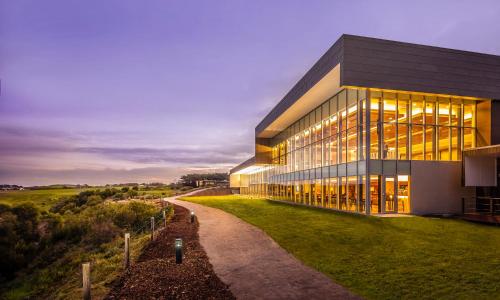 a large glass building with a pathway in front of it at RACV Inverloch Resort in Inverloch