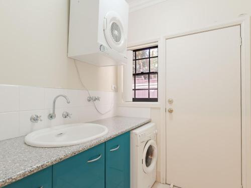 a bathroom with a sink and a washing machine at 2 11a Christmas Bush Avenue - fantastic pet friendly townhouse close to Dutchies Beach with Wi-Fi and Air Con in Nelson Bay