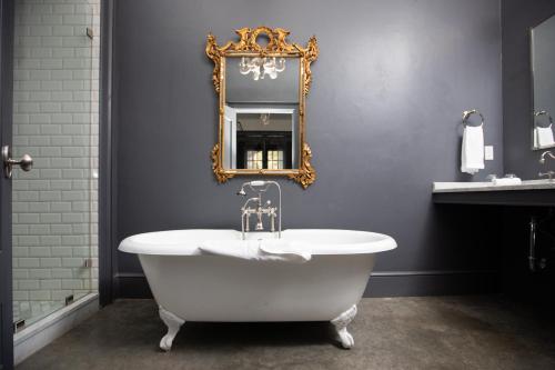 La salle de bains est pourvue d'une baignoire blanche et d'un miroir. dans l'établissement Surf Hotel & Chateau, à Buena Vista