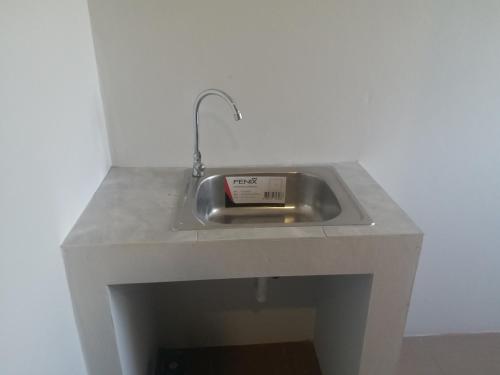 a kitchen sink with a clock in it at Saney Apartment in Ban Nong Ka Cha