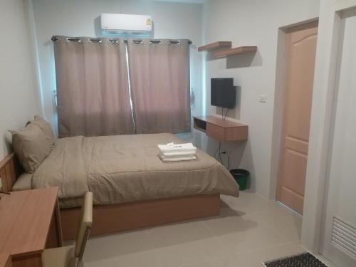a small bedroom with a bed and a television at Saney Apartment in Ban Nong Ka Cha