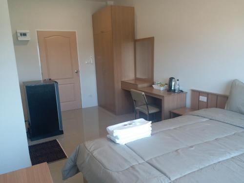 a bedroom with a bed and a desk and a television at Saney Apartment in Ban Nong Ka Cha