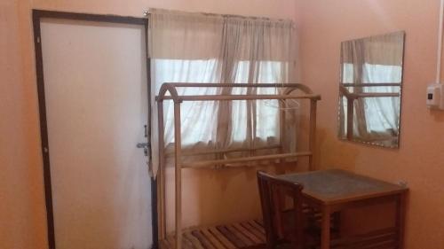 a room with two bunk beds and a table and a mirror at The 99 Inn Hotel in Ban Sao Thong