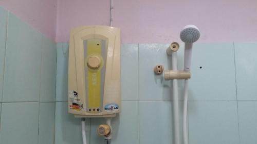 a toothbrush dispenser on a wall in a bathroom at The 99 Inn Hotel in Ban Sao Thong