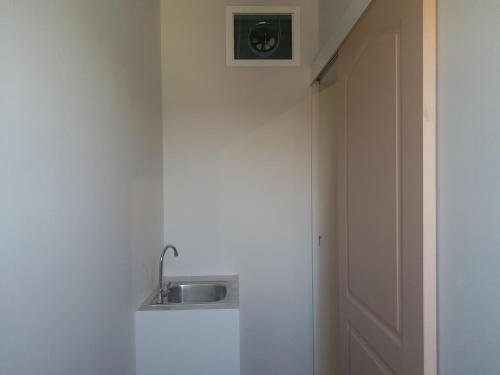 a sink in the corner of a room with a door at Saney Apartment in Ban Nong Ka Cha