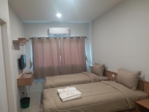 a hotel room with two beds and a window at Saney Apartment in Ban Nong Ka Cha