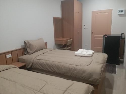 a hotel room with two beds and a television at Saney Apartment in Ban Nong Ka Cha