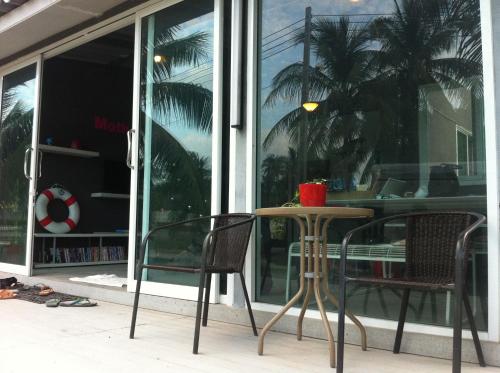 a table and two chairs in front of a window at Monkey Samui Hostel in Choeng Mon Beach
