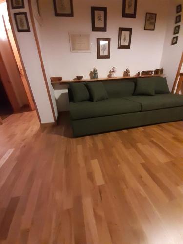 カナツェーイにあるCasa Italoのウッドフロアのリビングルーム(緑のソファ付)