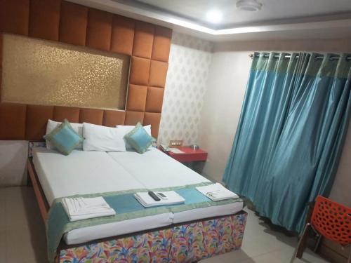 a bedroom with a bed with a blue curtain at Hotel Eastern Plaza in Kolkata