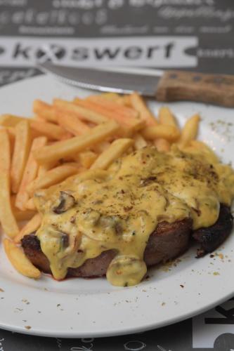 a plate with a piece of meat with cheese and french fries at ATKV Klein-Kariba in Bela-Bela