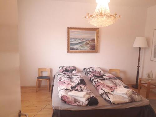 a bedroom with two beds and a chandelier at Puutarhakatu 1 bdr 62m2 in Turku