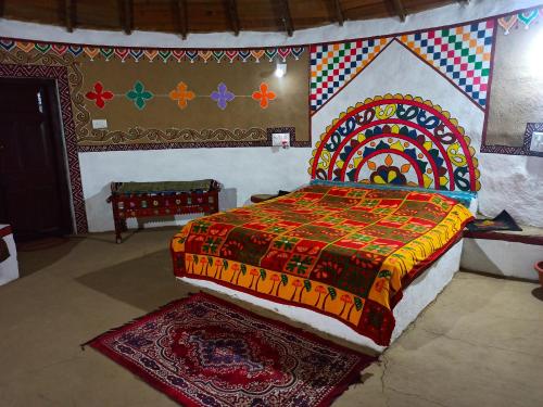 a bedroom with a bed with a colorful bedspread at Banni Village Stay in Bherandiāla