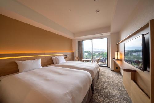 a hotel room with a large bed and a large window at Umekoji Potel KYOTO in Kyoto