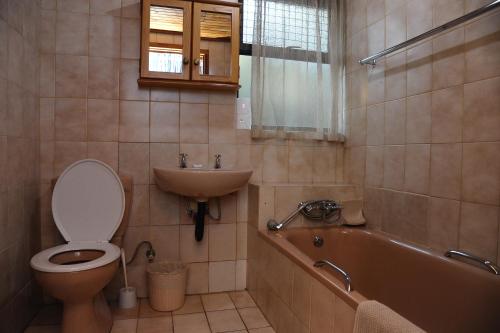 a bathroom with a toilet and a sink and a tub at ATKV Klein-Kariba in Bela-Bela