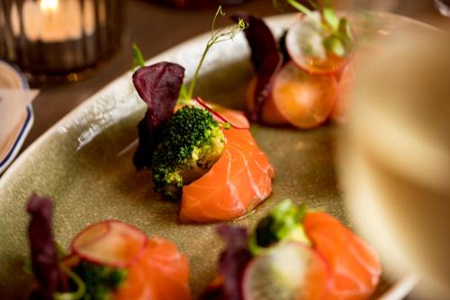 a plate of food with salmon and broccoli on it at Kempinski Hotel Hangzhou in Hangzhou