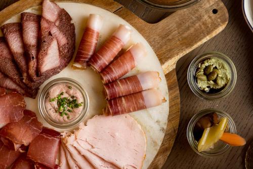 a plate of ham and other meats on a cutting board at Kempinski Hotel Hangzhou in Hangzhou