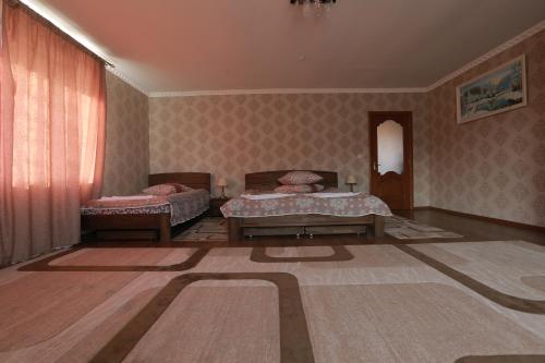 a room with two beds and a rug at Hotel Ashad in Svalyava