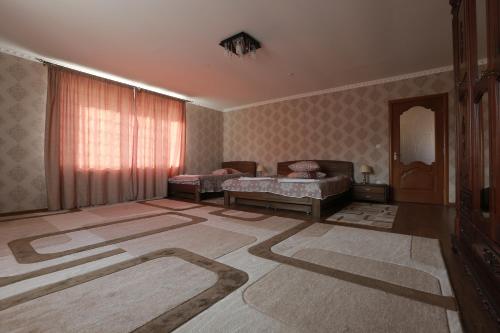 a living room with two beds and a carpet at Hotel Ashad in Svalyava