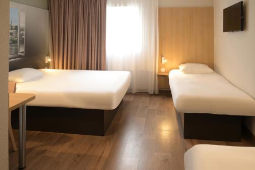 Ένα ή περισσότερα κρεβάτια σε δωμάτιο στο B&B HOTEL Angoulême