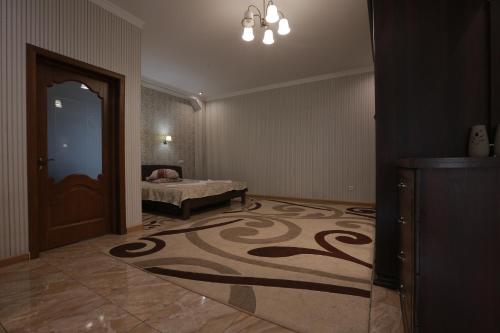a room with a bed and a door with a carpet at Hotel Ashad in Svalyava