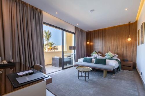 a bedroom with a bed and a couch and a table at Sirayane Boutique Hotel & Spa Marrakech in Marrakesh