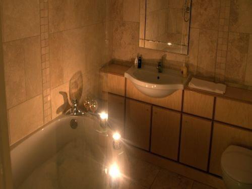 y baño con bañera, lavabo y luces. en Ellison Hall, en Hebburn-on-Tyne