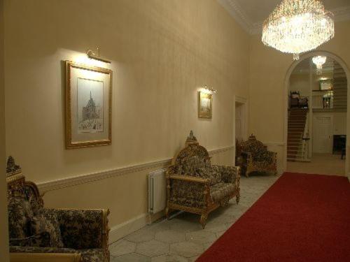 sala de estar con 2 sillas y lámpara de araña en Ellison Hall, en Hebburn-on-Tyne