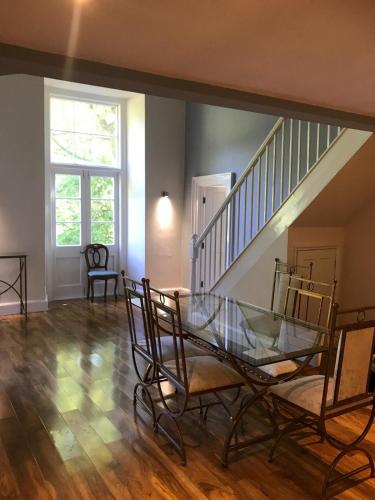 a living room with a glass table and a staircase at Ellison Hall in Hebburn-on-Tyne