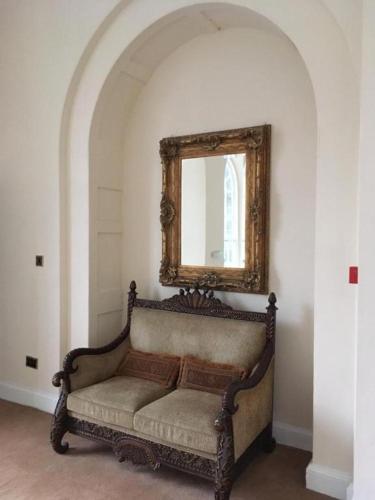 a couch in a room with a mirror on the wall at Ellison Hall in Hebburn-on-Tyne