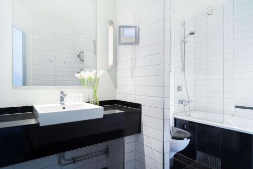 a white sink sitting under a mirror in a bathroom at Radisson Blu Hotel Malmö in Malmö