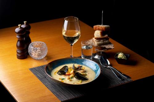 a bowl of soup and a glass of wine on a table at Radisson Blu Hotel Malmö in Malmö