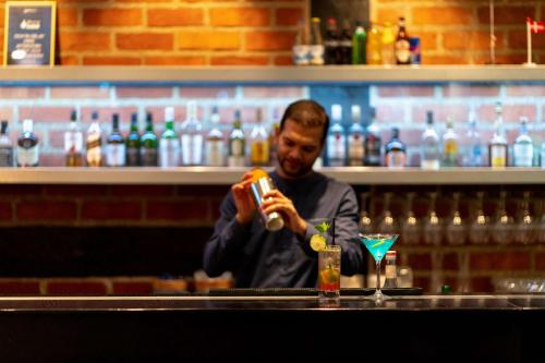 a man taking a picture of a drink at a bar at Radisson Blu Hotel Malmö in Malmö