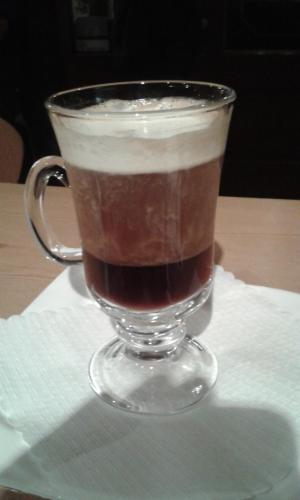 a glass cup of coffee sitting on a napkin at Landhaus Lenzenhof in Reit im Winkl