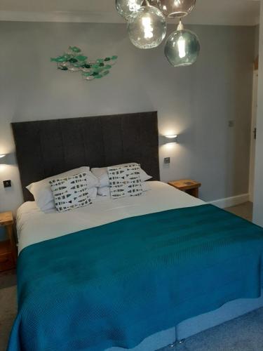 a bedroom with a large bed with a blue blanket at Seals Bacton in Bacton