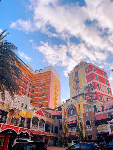 two tall buildings with cars parked in front of them at Sunset Beach Vacation House in Chatan