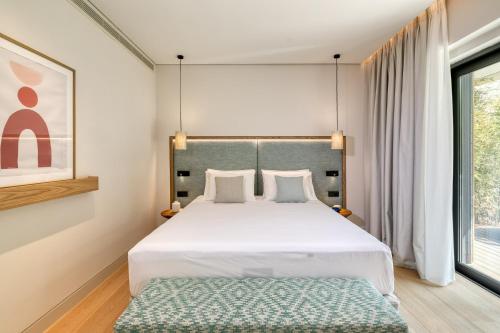 a bedroom with a large bed and a window at Vathi Cove Luxury Resort & Spa in Chrysi Ammoudia