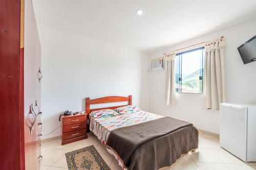 a bedroom with a bed and a window at OYO Residencial Muriqui Apart Hotel, Mangaratiba in Vila Muriqui