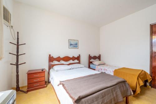 - une chambre avec 2 lits jumeaux et une commode dans l'établissement OYO Residencial Muriqui Apart Hotel, Mangaratiba, à Vila Muriqui