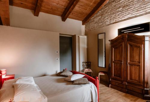 a bedroom with a large bed and a brick wall at Casa Baricalino in Novello