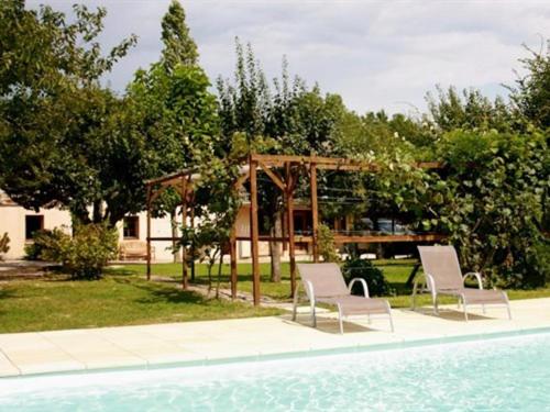 Saint-Jean-de-Thurigneux的住宿－萊斯巴利里斯酒店，游泳池畔的两把椅子和一个凉亭
