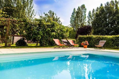 two chairs sitting next to a swimming pool at Les Barelles in Saint-Jean-de-Thurigneux